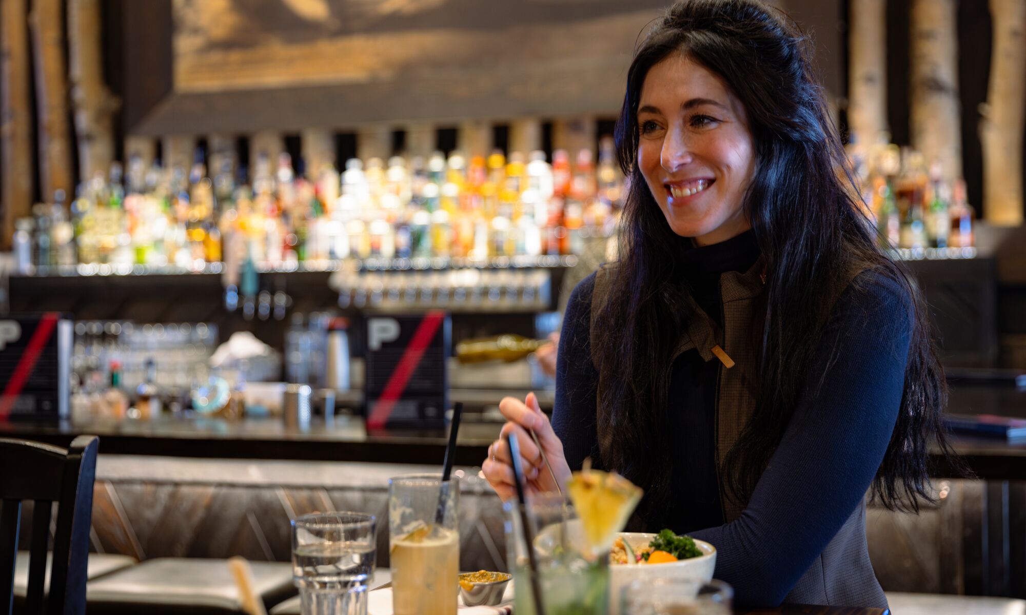 A woman has lunch at PARK Distillery in Banff National Park.